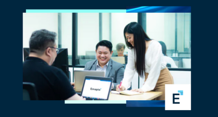 Three people in an office collaborate at a table with laptops. One writes notes while others smile, discussing outsourcing strategies for American businesses. The screen reads “Empasi 2025,” with the Empasi logo in the corner.